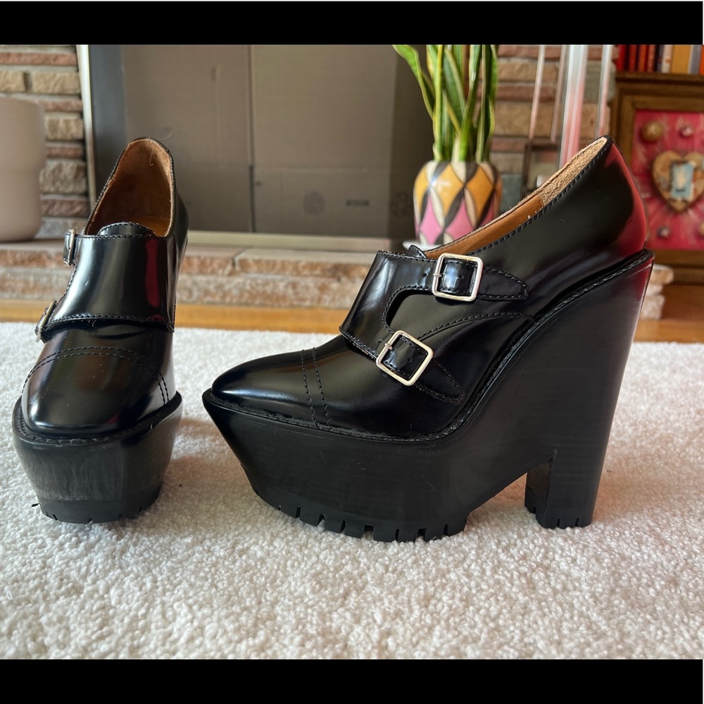 Burberry black leather pump platforms with silver buckles and rounded toe.